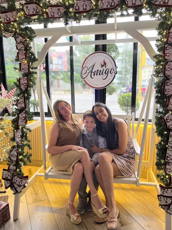 Familia en el columpio navideño con el logo de Amigos