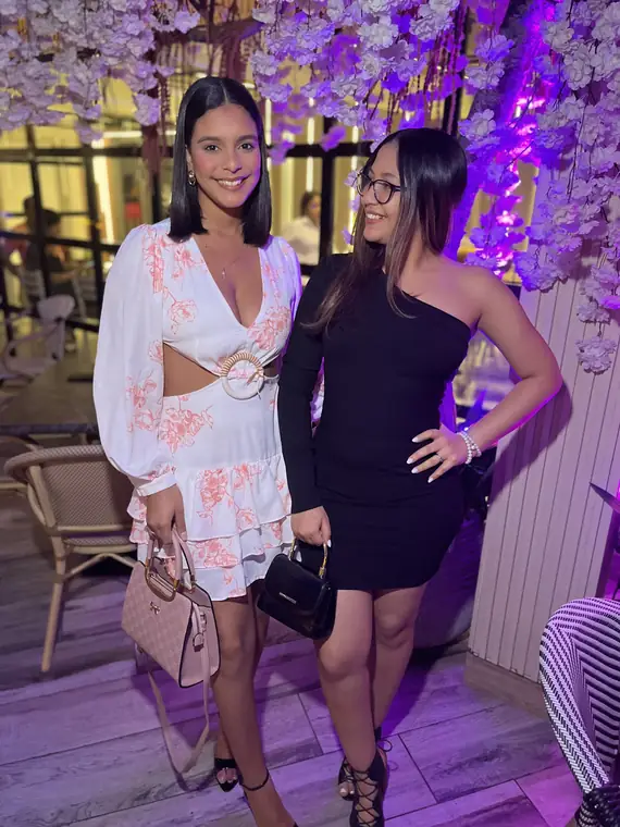 Amigas bajo las flores iluminadas en morado