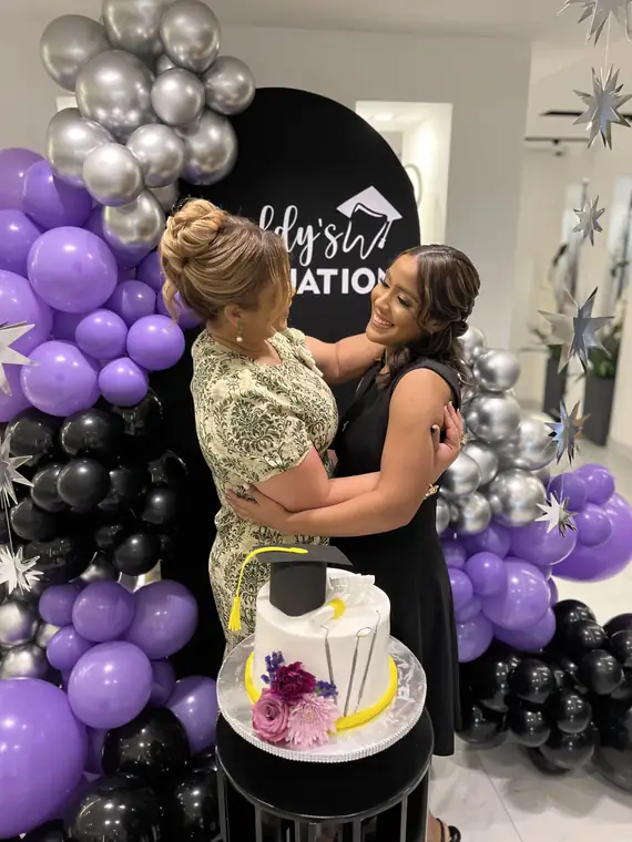 Graduación con bizcocho y globos morados y plateados