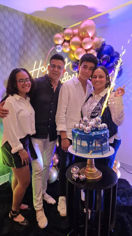 Familia celebrando unos 15 años con bizcocho azul