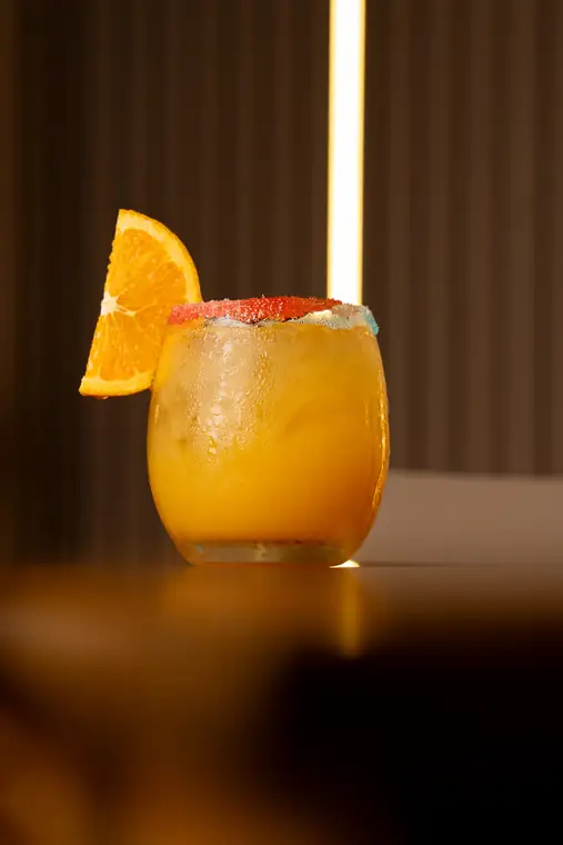 Cóctel tropical de naranja con escarchado de colores
