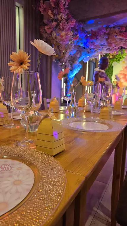 Mesa decorada con gerberas y cajitas de recuerdo