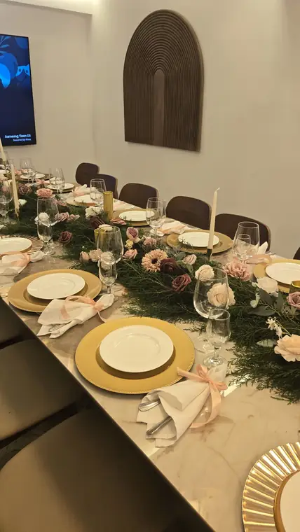 Mesa sobre mármol con camino de follaje y rosas
