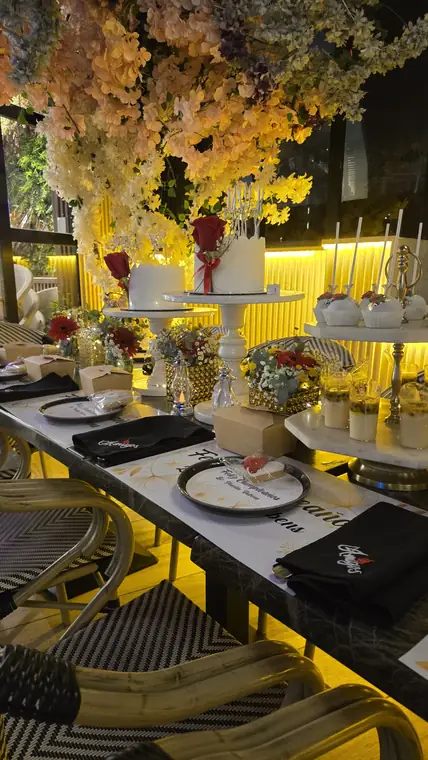 Mesa de cumpleaños con servilletas bordadas con el logo de Amigos