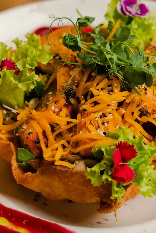 Grilled salmon in a crispy basket with greens