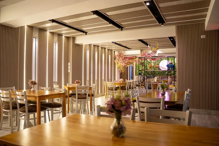 Salón principal con paneles de madera e iluminación lineal